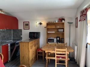 a small kitchen with a wooden table and a dining room at Studio Les Menuires, 1 pièce, 4 personnes - FR-1-452-138 in Les Menuires