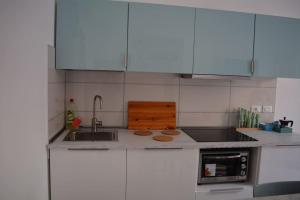 a kitchen with white cabinets and a sink at Casa Ortensia in Santa Teresa di Riva +24 photos