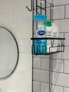 a shelf with toothpaste and a mirror on a wall at Entire Apartment in Waterloo in Waterloo