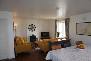 a living room with a table and chairs and a couch at 18 Ballybunion Holiday Cottages in Ballybunion