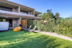a yard with two lawn chairs and a house at Villa moderne Cala Rossa Bay Les Oceanides in Lecci