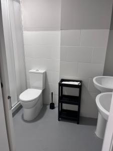 La salle de bains blanche est pourvue de toilettes et de 2 lavabos. dans l'établissement Unicorn Residence for students New Opening 2024, à Valence