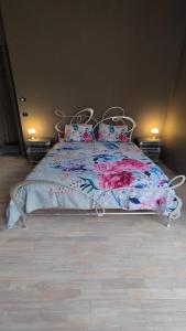 a bed with a floral bedspread and pillows on it at Villa Giordana in Casalborgone