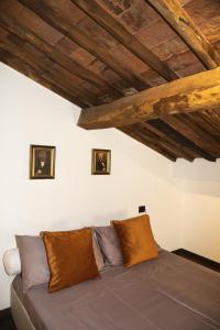 Ce lit se trouve dans un dortoir doté de plafonds en bois. dans l'établissement La Mansardina Beccheria Central Apartment 1 double bedroom, 1 sofa bed, à Lucques