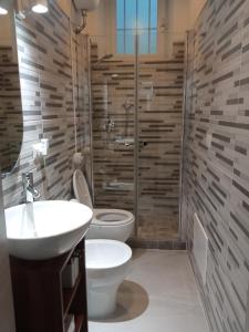 a bathroom with a toilet and a sink and a shower at Voyager in Cagliari
