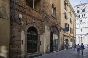 a group of people walking down a street next to buildings at La Mansardina Beccheria Central Apartment 1 double bedroom, 1 sofa bed in Lucca
