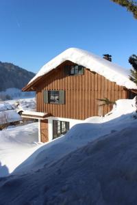 una casa con nieve en el techo en Ferienhaus Alpkönigin in Missen mit Garten und Terrasse, en Missen-Wilhams