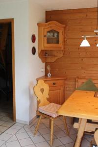 een keuken met een tafel en een houten muur bij Ferienhaus Alpkönigin in Missen mit Garten und Terrasse in Missen-Wilhams
