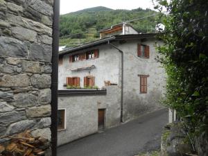 a stone building with a balcony on a street at B&B LA SPINA 2 in Poggiridenti
