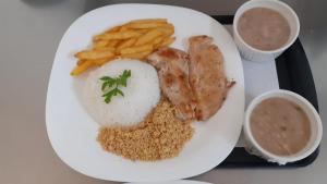 un plato de comida con arroz de pollo y papas fritas en Hotel Karinho 2, en Santo André