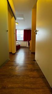an empty room with a hallway with a door and a bedroom at Hotel Gifhorn INN in Gifhorn