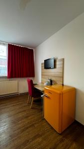 a room with a desk and a red curtain at Hotel Gifhorn INN in Gifhorn