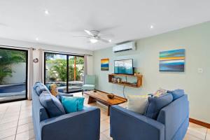 un salon avec deux chaises bleues et une table dans l'établissement Inviting Home with Colorful Decor and Private Backyard Oasis with a Swimming Pool & Shaded Terrace, à Santa Cruz