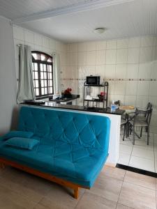 - un canapé bleu dans une chambre avec cuisine dans l'établissement Cantinho do Aconchego, à São Lourenço