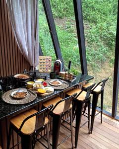 uma mesa preta com cadeiras e comida em Chalé com Cachoeira em Witmarsum