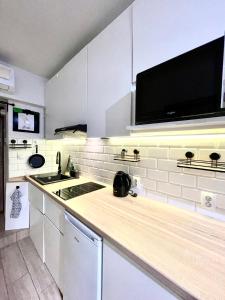 a kitchen with a counter with a sink and a microwave at City Break Smocza Jama Apartment in Kraków