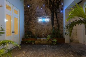 un couloir avec un mur en briques et une porte blanche dans l'établissement Casa Acomodo Casco Viejo 4bdr Historic Mansion, à Panama City