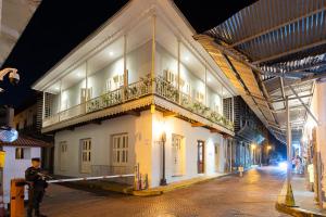 un oficial de policía de pie fuera de un edificio por la noche en Casa Acomodo Casco Viejo 4bdr Historic Mansion en Panamá