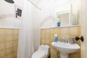 ein Badezimmer mit einem Waschbecken, einem WC und einem Spiegel in der Unterkunft Casa Acomodo Casco Viejo 4bdr Historic Mansion in Panama-Stadt