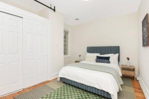 ein weißes Schlafzimmer mit einem Bett und einem Fenster in der Unterkunft Fun & Funky 2BR in Downtown Princeton in Princeton