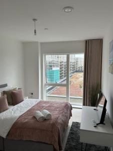 a bedroom with a bed and a large window at Contemporary Urban Retreat, 2-Bedroom Haven by London City Airport in London