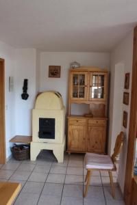 eine Küche mit einem Herd und einem Stuhl in einem Zimmer in der Unterkunft Alpkönig I - Ferienhaus in MissenOberallgäu in Missen-Wilhams