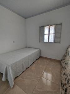 um quarto com uma cama e uma janela em Rancho yaci em Alexânia