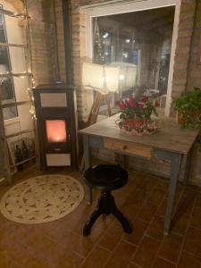 Zimmer mit einem Tisch und einem Holzofen in der Unterkunft Agricola casa cucina bottega in Cesena
