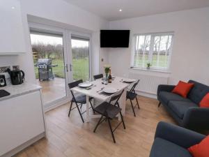 a kitchen and a living room with a table and a couch at Oak Lodge in Ashbourne