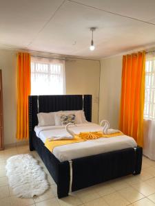 1 dormitorio con 1 cama con cortina naranja en Lefad Apartment-3Bedrooms own compound, en Kisumu