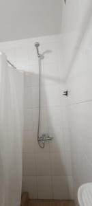 a shower in a white bathroom with a sink at La Via Apart in Bahía Blanca