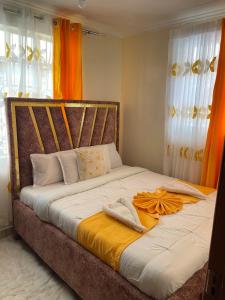 sypialnia z łóżkiem z pomarańczową zasłoną w obiekcie Lefad Apartment-3Bedrooms own compound w mieście Kisumu
