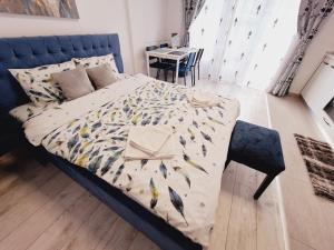 a bedroom with a bed with a bird patterned blanket at Mirvana Apartments Allure Studio in Timişoara