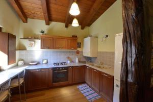 a kitchen with wooden cabinets and a stove top oven at Maison Crè in La Salle