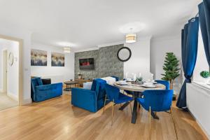 a dining room and living room with blue chairs and a table at Secret Abode in Harrogate in Harrogate