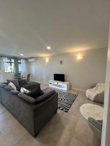 a living room with a couch and a tv at Feels Like Home Condo Victoria Falls in Victoria Falls