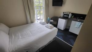 a bedroom with a white bed with a window at Nysdill Hotel Norwich in Norwich