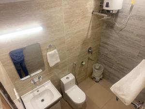 a bathroom with a white toilet and a sink at Pinnacle Vesta Homestay in Mussoorie