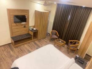 um quarto de hotel com uma cama e uma televisão em Pinnacle Vesta Homestay em Mussoorie