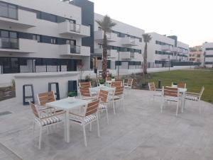un grupo de mesas y sillas en un patio en Bajo con jardin en primera línea de playa, en Málaga