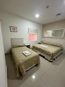 Cette chambre comprend 2 lits et un miroir. dans l'établissement Gran Hotel Laserre, à Río Grande