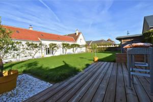 a backyard with a wooden deck and a lawn at studio bocagère in Amblainville