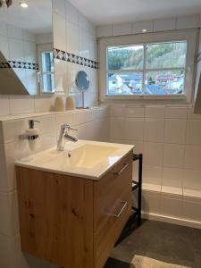 a bathroom with a sink and a window at Gästezimmer Adenau in Adenau