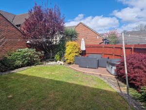 a backyard with a patio and a dog in the yard at 7 Ash Close in Rolstone
