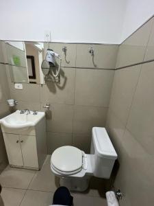 a small bathroom with a toilet and a sink at Gran Hotel Laserre in Río Grande