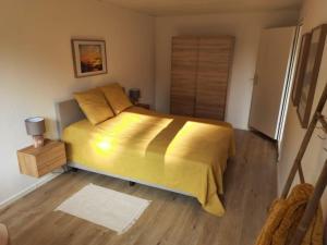 sypialnia z łóżkiem z żółtą narzutą w obiekcie FeWo Steuerbord w mieście Malente