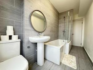 a bathroom with a sink and a toilet and a mirror at Two Bedroom Apartment Near Park Lane in London