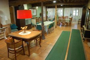 comedor con mesa, sillas y lámpara roja en Posada Casa Juanes en Valdealvillo