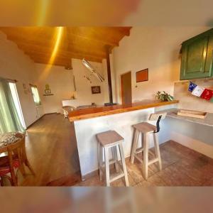a kitchen with a counter and two stools in a room at Buddha Tempo in Esquel