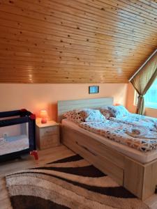 a bedroom with a bed and a wooden ceiling at Jázmin Apartman Zalakaros in Zalakaros